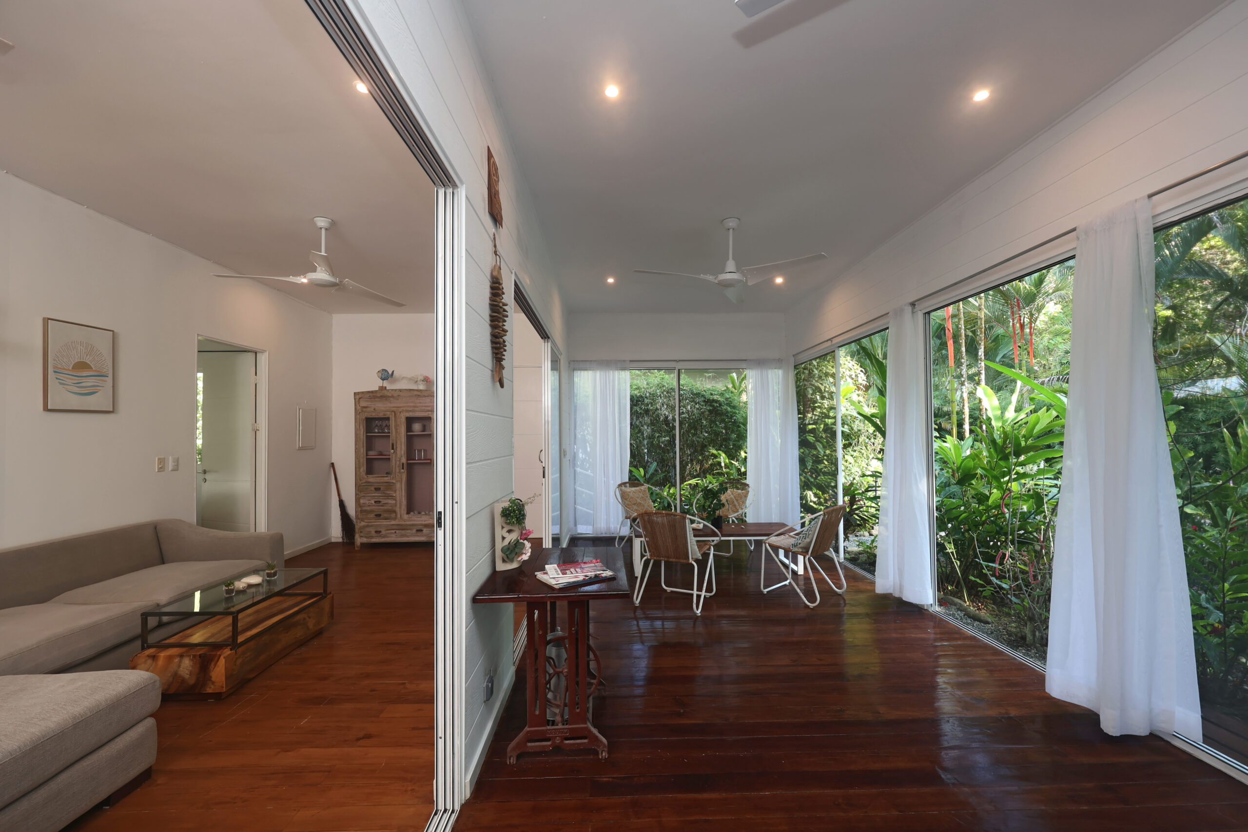 Modern villa patio seating with white curtains and tropical garden views at Ojochal Gardens resort