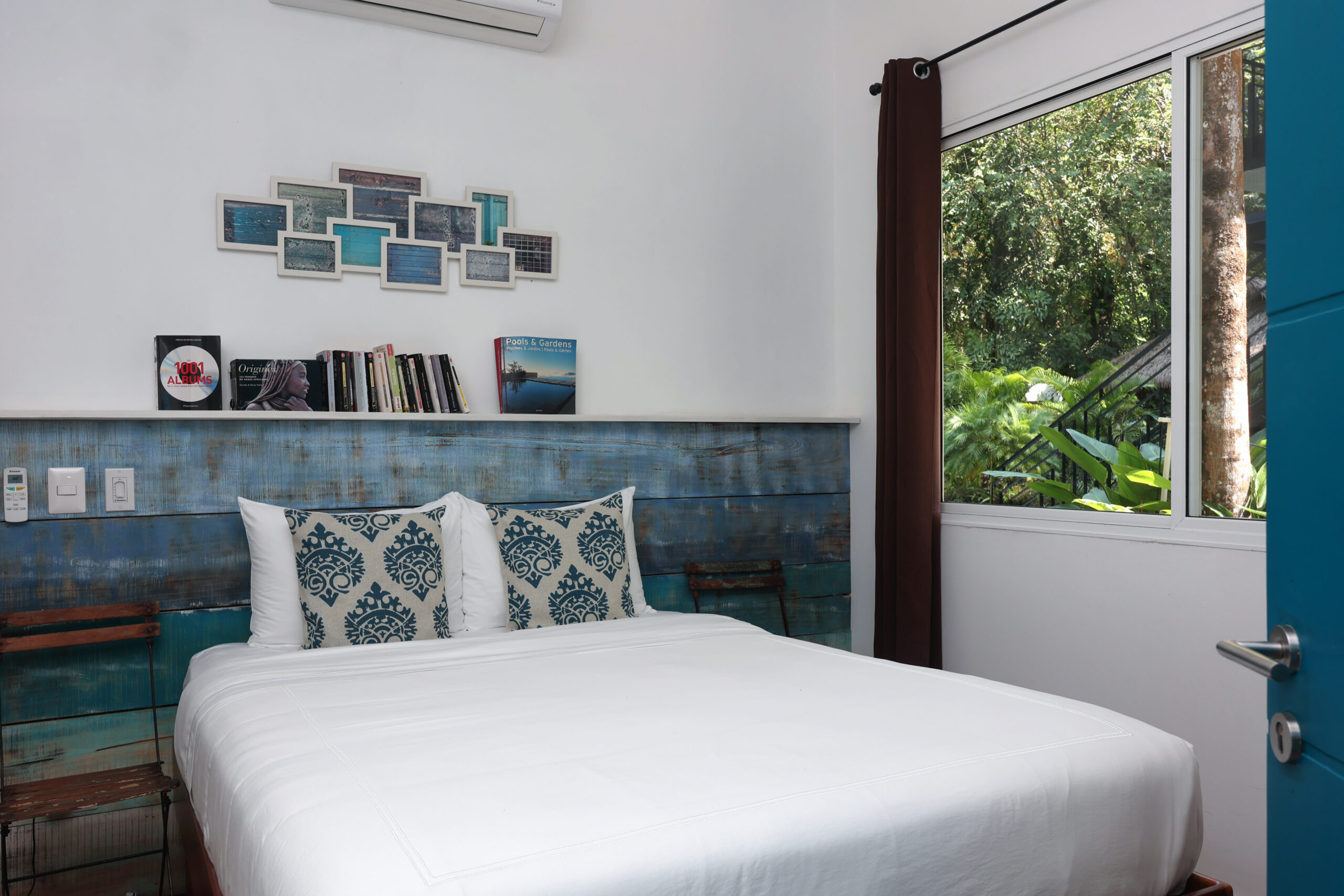 Villa bedroom featuring weathered blue wood headboard wall